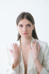 Trending silver jewelry set on a beautiful young girl in a white fashionable jacket  with long dark hair. Beauty and fashion 
