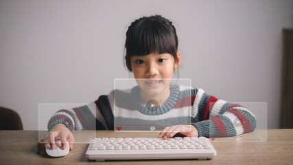Asian girls use mouse and keyboard for streaming online, watching video on internet, live study, tutorial, online learning, education, home schooling. during Covid-19 pandemic lockdown.