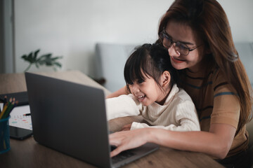 Mother working at home-office with daughter on her lap