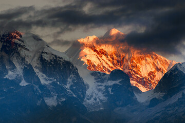 Schönes erstes Licht von Sonnenaufgang auf dem Berg Kanchenjugha, Himalaya-Gebirge, Sikkim, Indien. Orangefarbene Tönung auf den Bergen im Morgengrauen