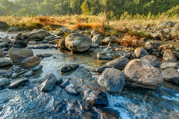 Fototapeta na wymiar Beautiful Reshi River water flowing on rocks at dawn, Sikkim, India - a spectacular view , tinted image