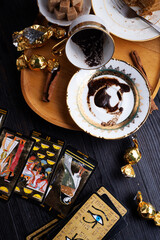 spelling coffee plate  with  coffee grounds and Tarot cards served at dark wooden table. devination concept