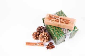 Christmas gift wrapped and decorated with cinnamon sticks, some cones and star anise	
