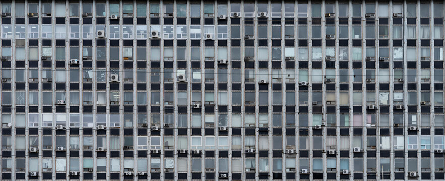 Old Soviet building brutalism style. Lots of windows and floors. Administrative or office building. Texture, window pattern.
