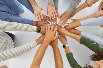 Team of people joining hands in corporate meeting. Group of coworkers, teammates and friends...