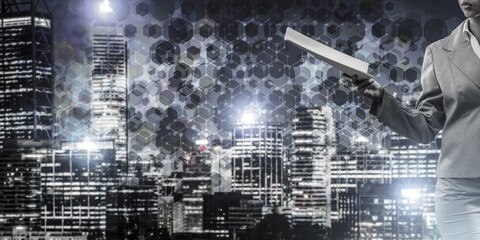 Close of businesswoman against night cityscape background and technology concept