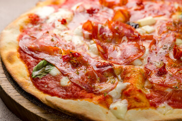 Pepperoni pizza with cheese and basil on wooden board macro close up