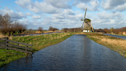 Dutch windmill on the water with the name  De Onrust or Meermolen, near the small town of Muiderberg on the Naardermeer. © Jan van der Wolf