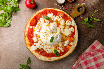 Pizza with burrata cheese, tomato sauce and basil top view on brown concrete table
