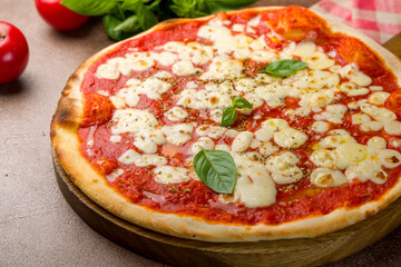 Italian pizza Margherita with tomato sauce and basil on wooden table