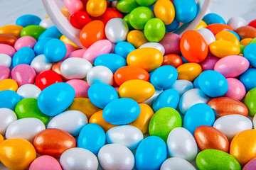 Fototapeta na wymiar jars almond candies, marshmallows. Colorful traditional candies, chocolates and Almond candy in a glass bowl on marble background, close up