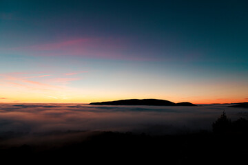 Sunset seen from the top of the mountain in a sea of ​​clouds