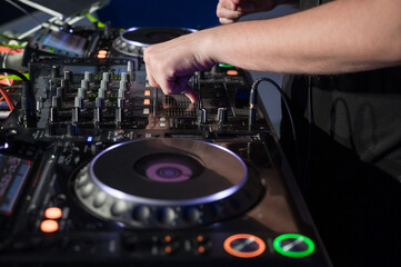Obraz premium Close-Up of Dj Mixer Controller Desk in Night Club Disco Party. DJ Hands touching Buttons and Sliders Playing Electronic Music . High quality photography.