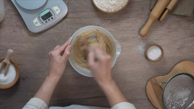 Woman prepairing dough mixing the ingredients in a bowl
