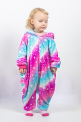 Gentle girl 2 years old in pink with lilac unicorn kigurumi on a white background