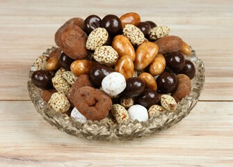 Assorted chocolate and coated candies. Delicious sweets placed in a bowl on the wooden table.