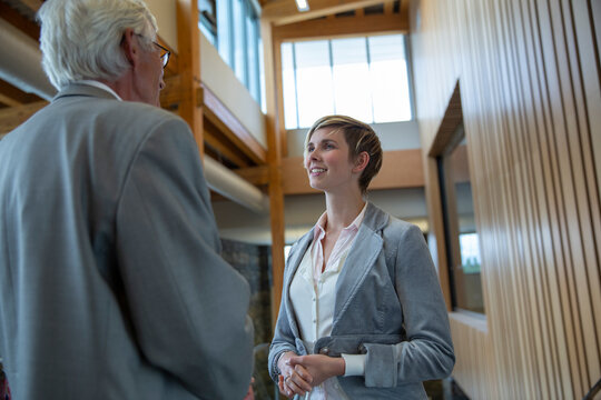 Business people exchanging business cards in office lobby