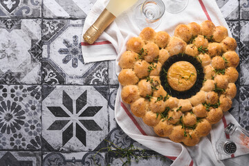 Bread buns heart shaped with Roasted camembert cheese and rosemary on rustic background. Holiday recipes. Valentines Day menu. Concept of romantic love for Valentines Day. Top view, copy space.