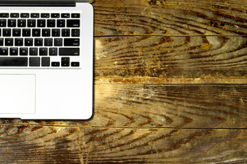 Modern aluminum computer keyboard isolated on wooden background