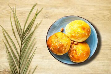 Burger Bread in plate with palm leaf plant on wood table