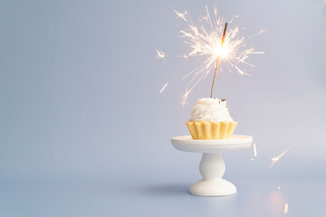 cake on a white stand with sparklers on white background. birthday cake.