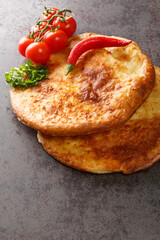 Georgian khachapuri mingrelian with sulguni cheese close up in the table. Vertical