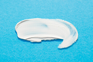 A smear of cream or face mask. The appearance of the texture of the cream on blue background. Skincare products , natural cosmetic. Beauty concept for face and body care