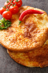 Georgian khachapuri mingrelian with sulguni cheese close up in the table. Vertical top view from above