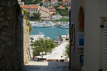 Blick durch eine enge Gasse auf den Hafen der Stadt Rab in Kroatien
