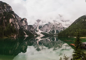Foto op Plexiglas Lake lago di braies panorama in a foggy morning with glaciers mountain and reflection in dolomite alp, Italy © Martin