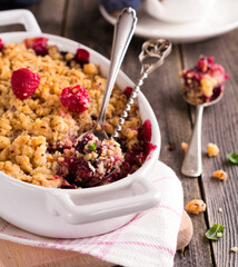 Plum and raspberry crumb on the old wooden background. Rustic style. Selective focus.