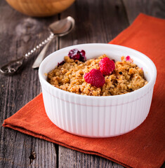 Plum and raspberry crumb on the old wooden background. Rustic style. Selective focus.