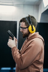 Face profile of a serious man holding a short-barreled weapon