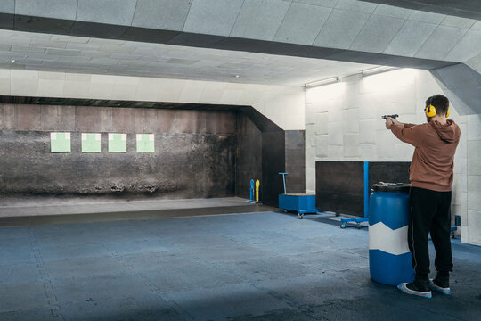 Long range shooting in a shooting range. A man shoots a short-barreled weapon