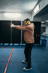 A man stands in the correct position for shooting and prepares to hit the target