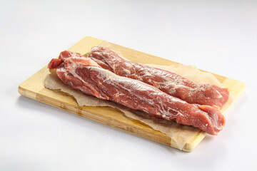 Raw pork tenderloin over board