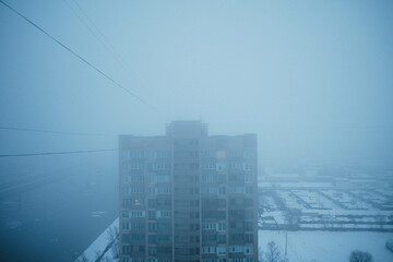 Roof of the house in thick fog, dark blue sky