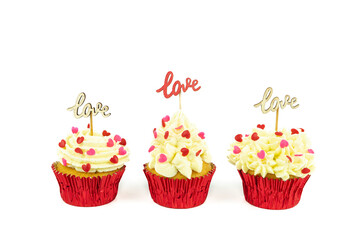 Three cupcakes on a white background with wooden signs with the word LOVE. Valentine's Day.
