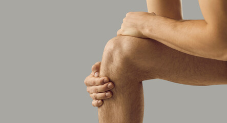 Narrow crop shot of man touch kneecap suffer from acute ache. Pain in knee. Unhealthy sick male...