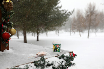 Paper cup with a drink on a winter snowy day