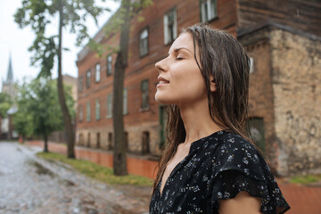Portrait of a woman in rainy day. Summer rain in the city. Beautiful female portrait