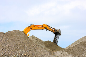 heavy machinery digs sand, excavator at work