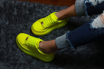 Fluorescent green women's tennis shoes on a black background