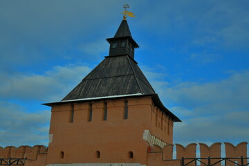 brick kremlin tower with wooden roof and weather vane
