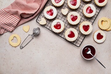 Linzer cookies in shape of heart with jam on light background. Mother's day, Women's day, Valentine's day. Homemade present. Copy space, top view.