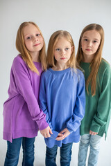 Caucasian teen happy girls in colorful cardigans laughing together. Blondie caucasian little girls
