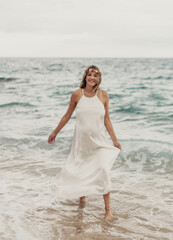Fototapeta na wymiar Sesion de fotos de una mujer embarazada paseando por la playa