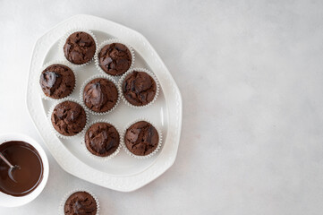 Chocolate muffins with chocolate chips in a oval plate. Top view.