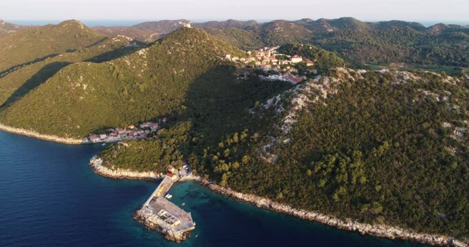 Aerial view of a small pier for ferry along the coast facing the Adriatic Sea near Lastovo, Croatia.