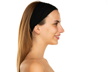 Side view portrait of adorable happy young woman with brown hair and headband